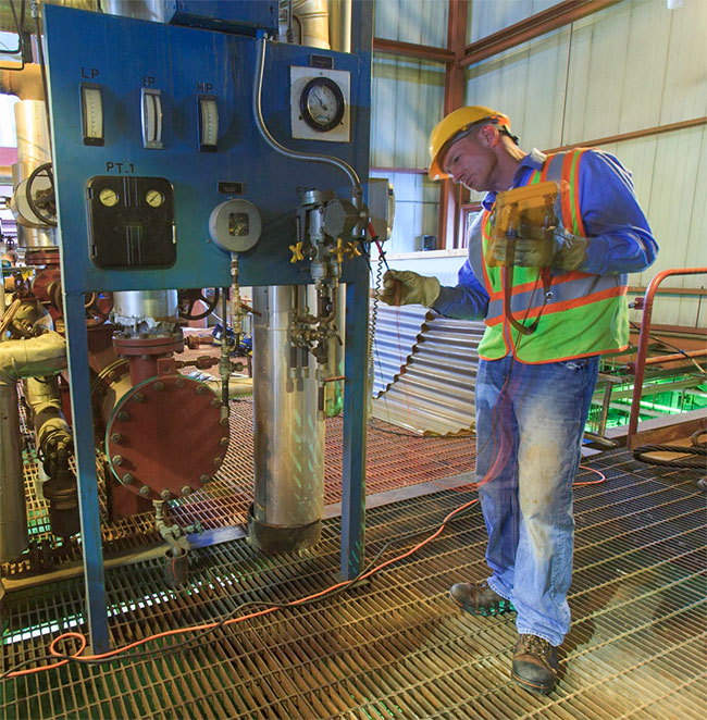 A technician working on an industrial control panel